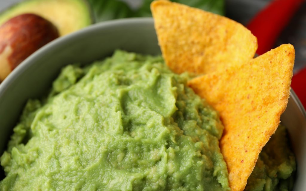 bowl of guacamole with tortiall chips